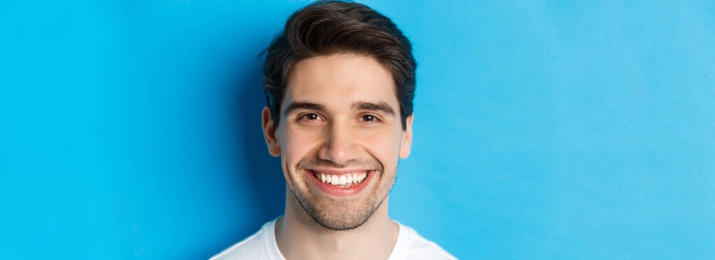 A man with perfectly white teeth showcasing porcelain veneers in Los Angeles